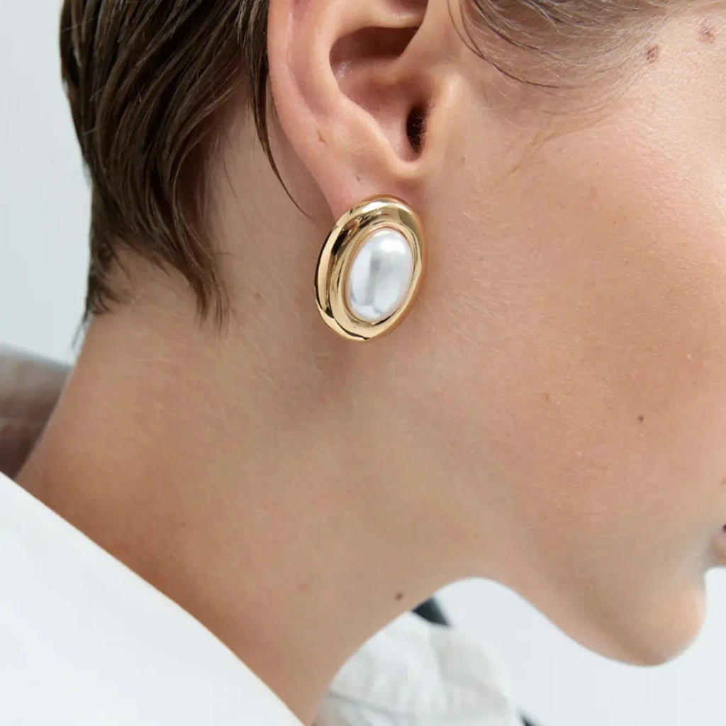 A pair of stainless steel vintage pearl ball stud earrings with surgical steel posts on a white background.