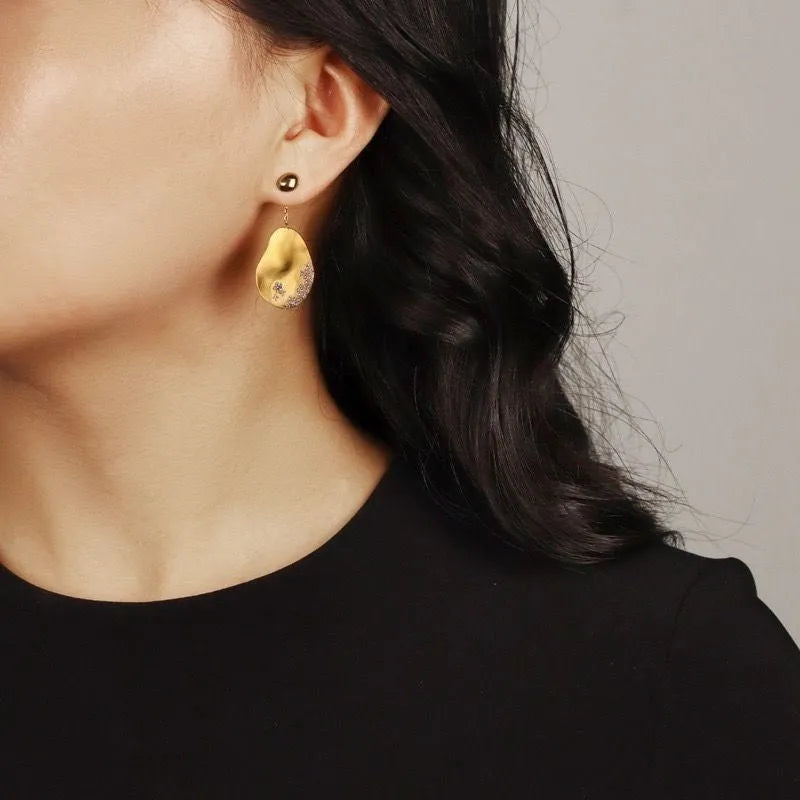 Asymmetric floral earrings with zircon mosaic detail in gold or silver colour