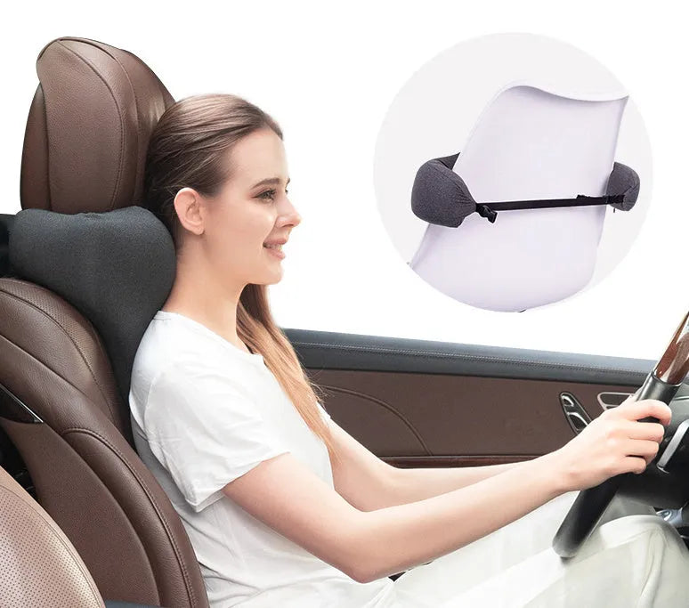 Dark gray memory foam car neck pillow on a car headrest.