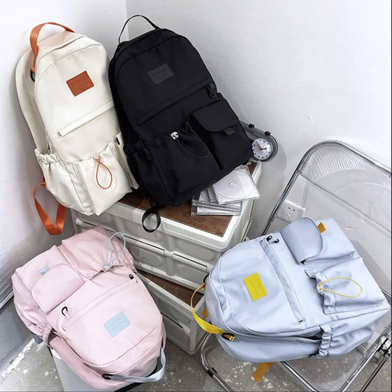 Nylon backpack school bag for junior high students, waterproof, lightweight, available in black, blue, pink, and white colours