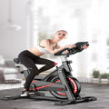 Black upright spinning bike with padded saddle and handlebars for home fitness