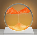 Creative quicksand painting rotary night lamp on a desk, showing abstract colours inside a 12-inch glass cylinder.