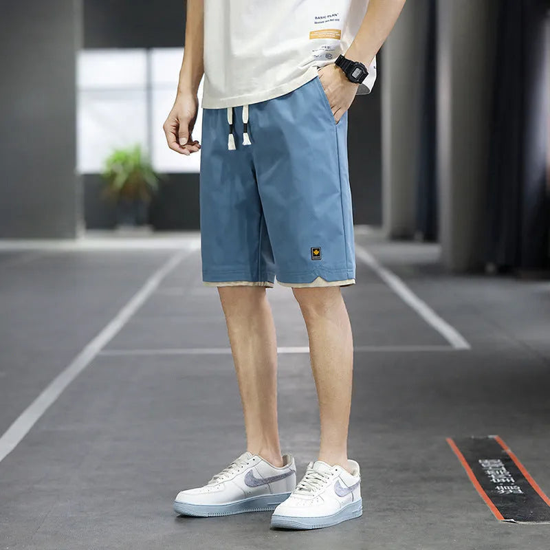 Casual straight-leg loose shorts in green polyester fabric on a neutral background.
