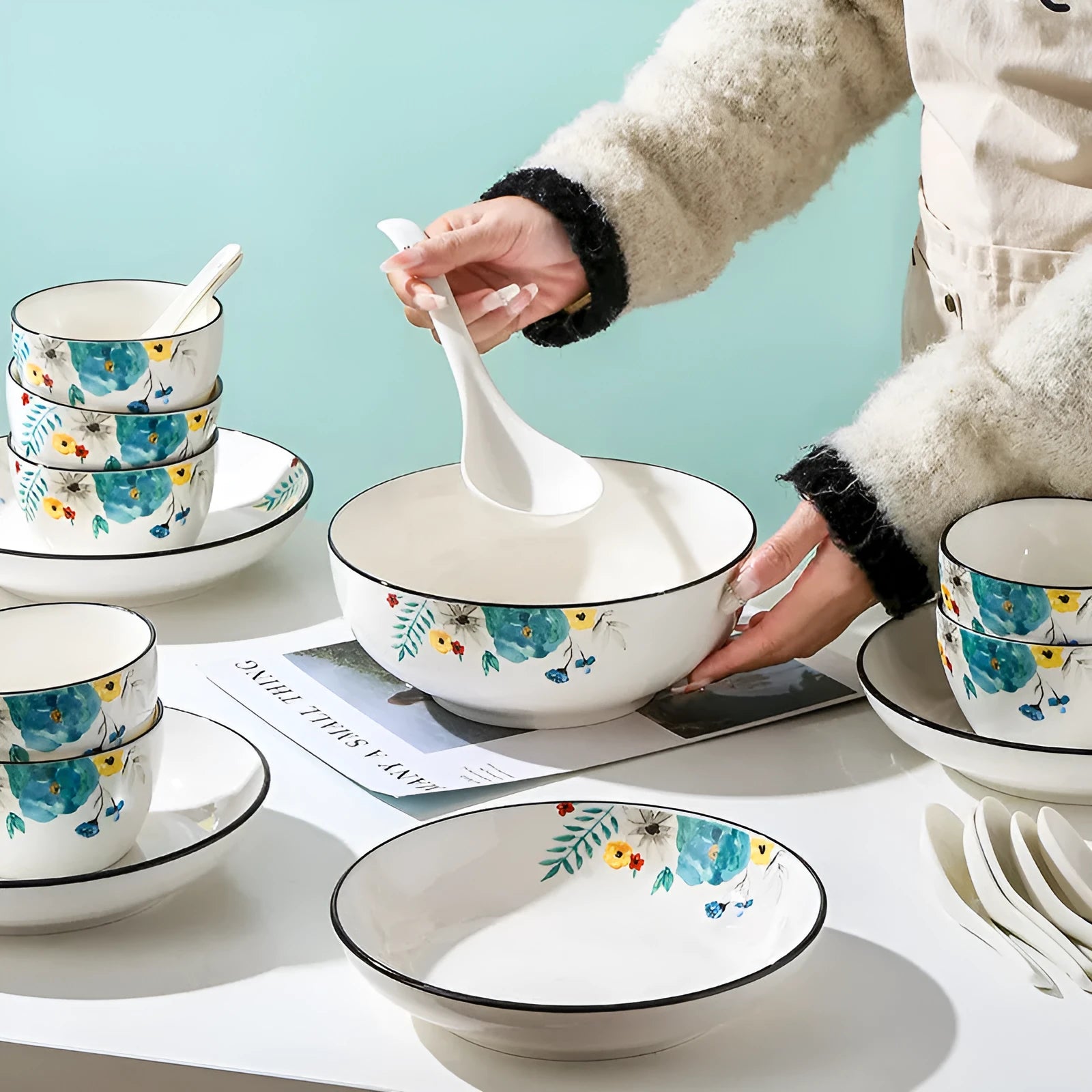 Flower In Ink 22-piece bone china tableware set with floral pattern, bowls, plates, and spoons on a table.