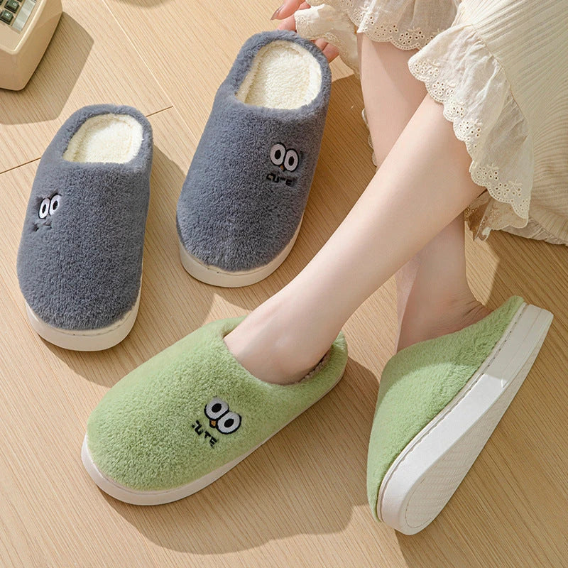 Cozy cartoon slippers with big eyes in various colors, featuring plush material and non-slip rubber soles for comfortable indoor wear