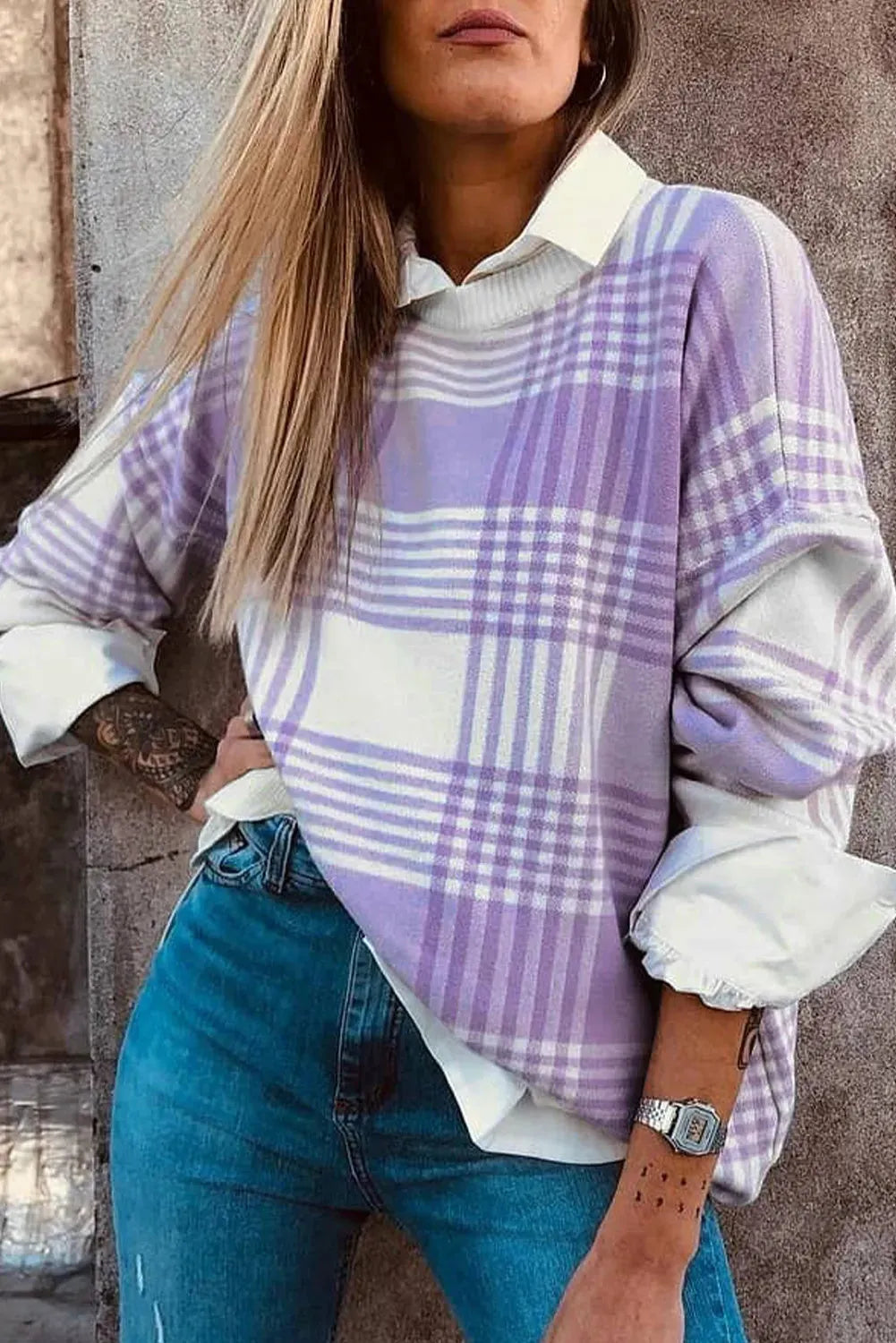 Loose lilac plaid print sweater with ribbed trim and long sleeves on a hanger.