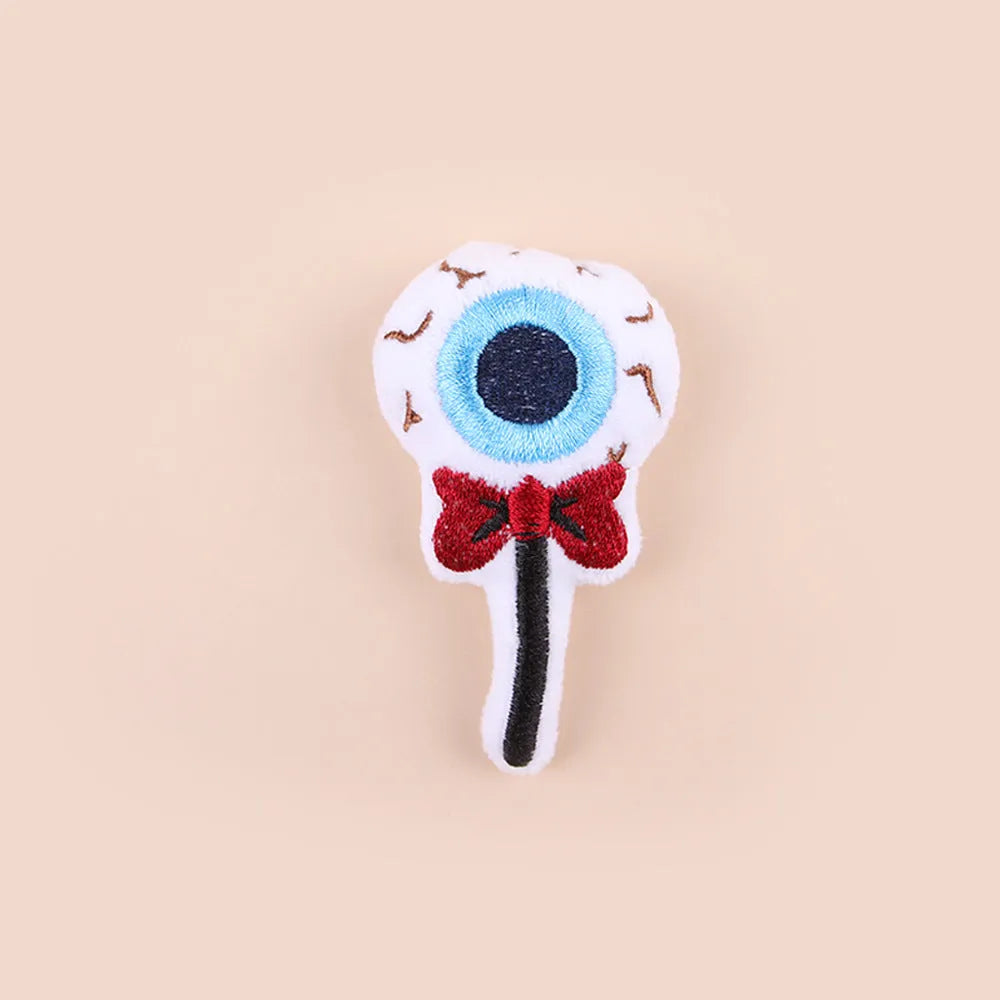 Small plush candy cat teaser wand on a stick in one of three colour designs: Eyes, Candy, or Skull.