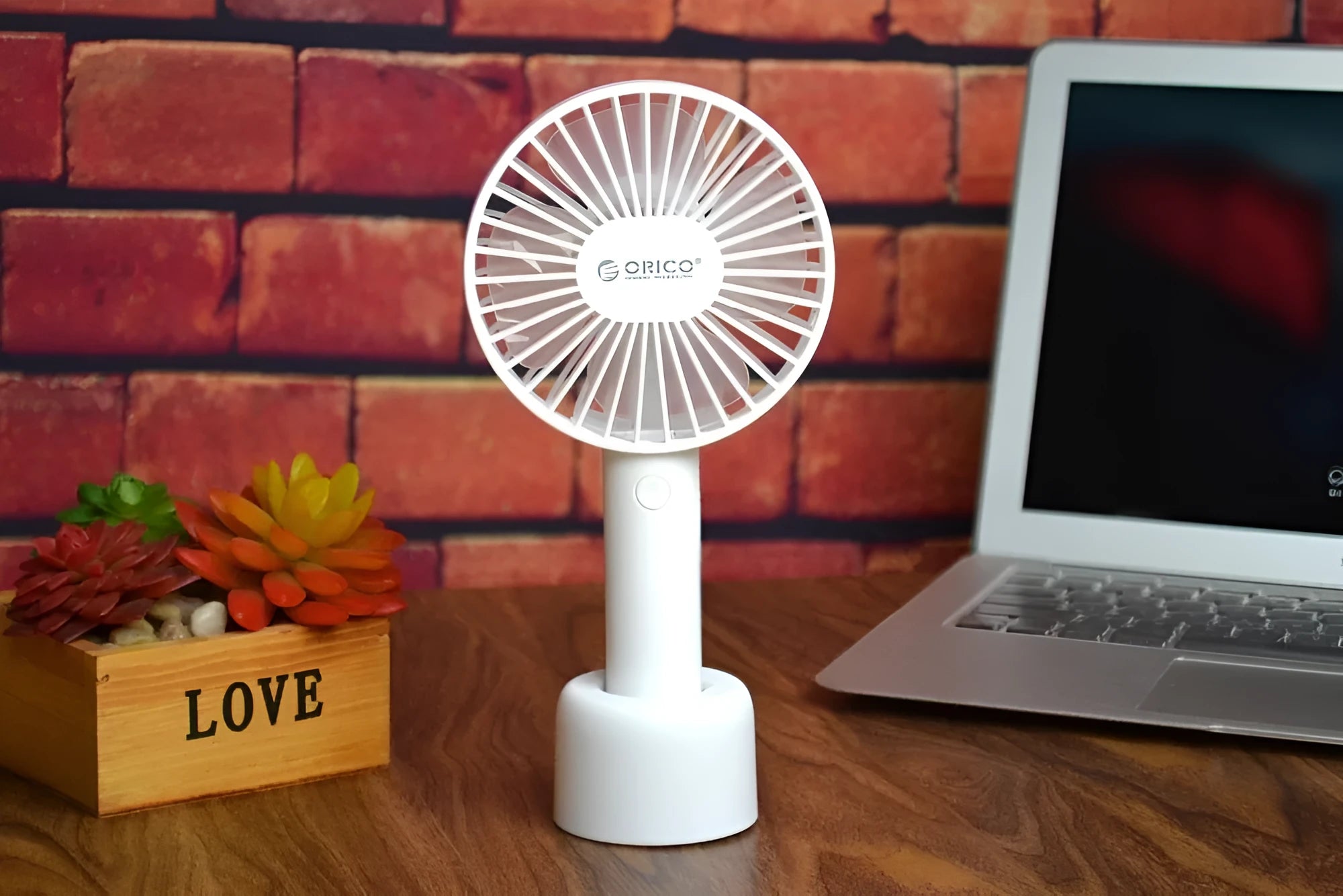 White ORICO FH1 portable USB rechargeable desk fan with three-speed buttons and a fine line pattern on its ABS shell.