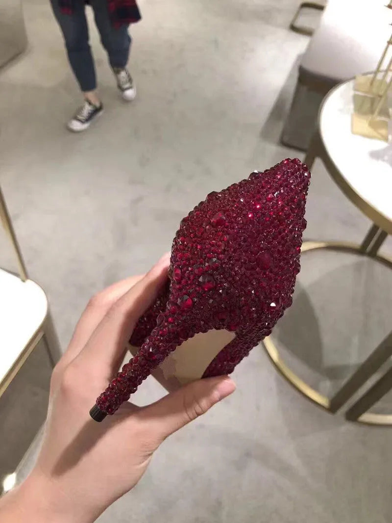 Women's gold sequinned pointed toe high heels with rhinestone details and a stiletto heel.