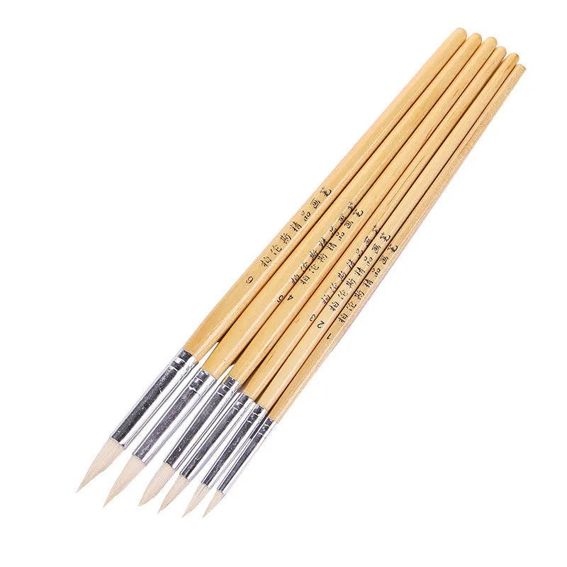 6 wooden artist paintbrushes with pointed handles and wool brush heads arranged together