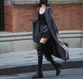 Long grey knitted hooded trench coat on a hanger, showing cardigan front and loose fit.