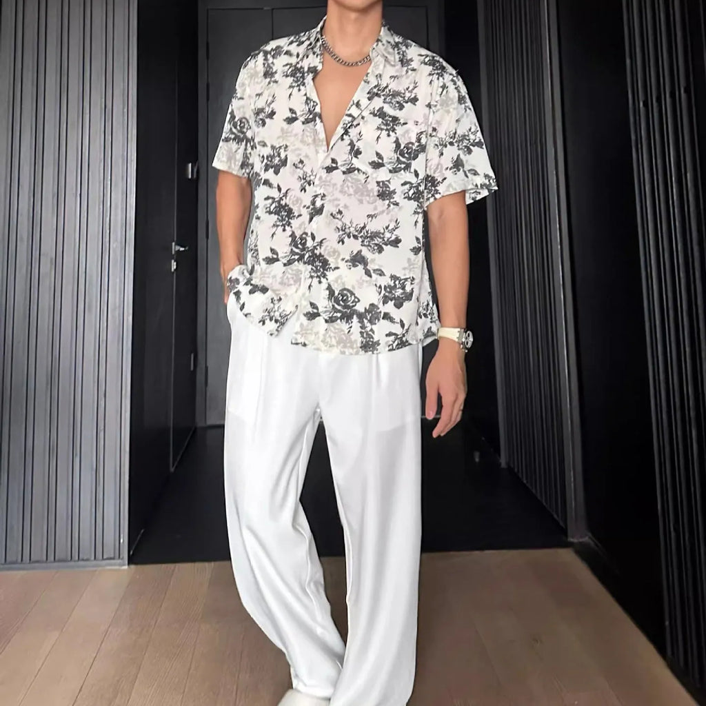 Men's loose-fit black short sleeve shirt with a white floral print pattern.