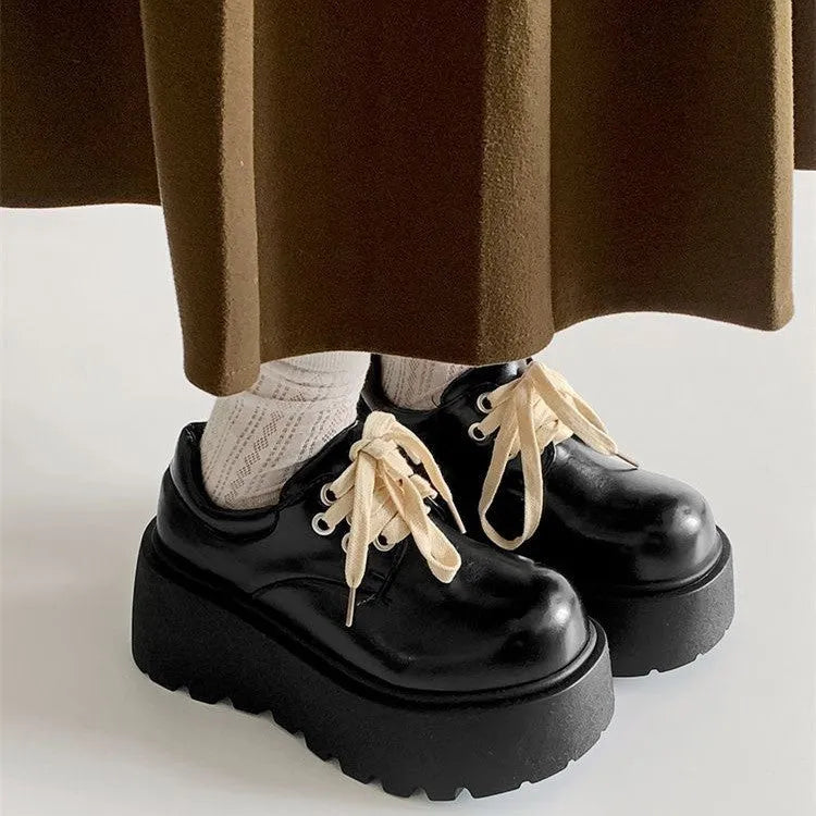 Matte black women's lace-up platform shoes with thick rubber sole and retro block heel.