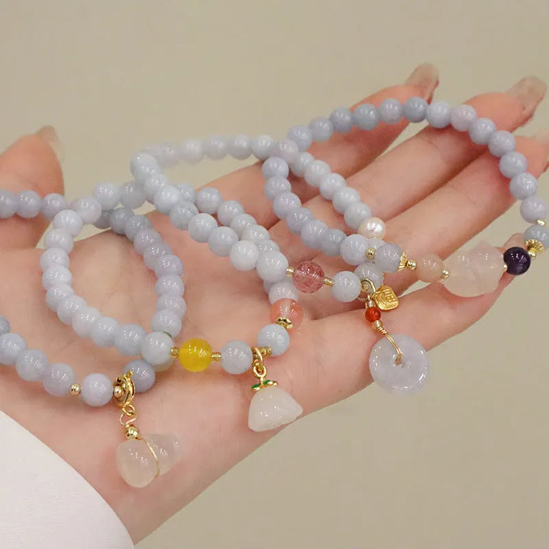 Gold plated women's bracelet with aquamarine chalcedony crystal pendant and floral design.