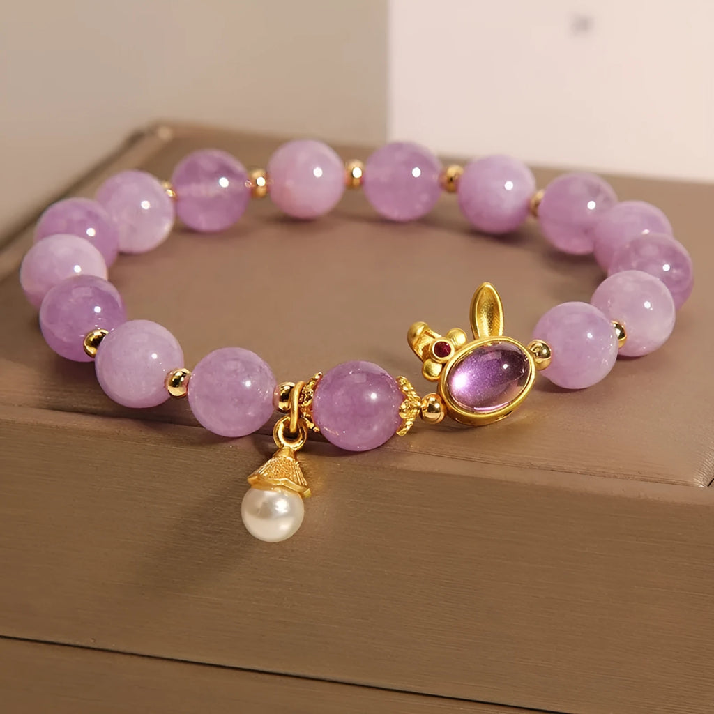 Natural mauve jade rabbit bracelet with crystal band and purplish red hare head charm.