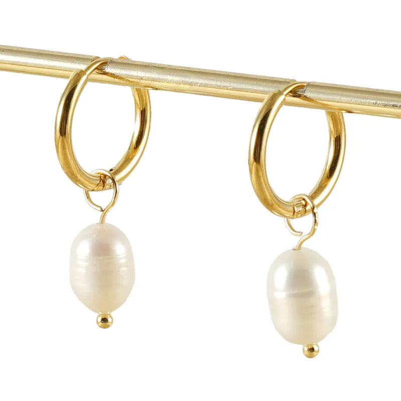 A pair of gold geometric earrings with pearl details on stainless steel and titanium steel posts.