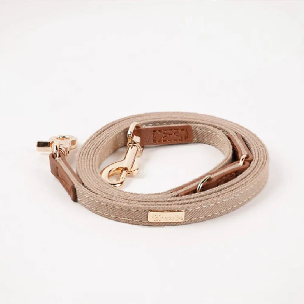 Adjustable mohair dog collar with nameplate and hand holding rope in cement gray