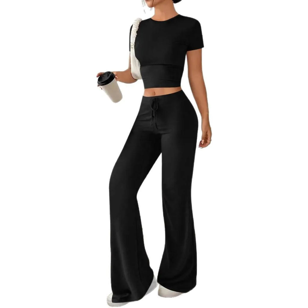 Black high-waist trousers and matching short-sleeve T-shirt co-ord set laid flat.