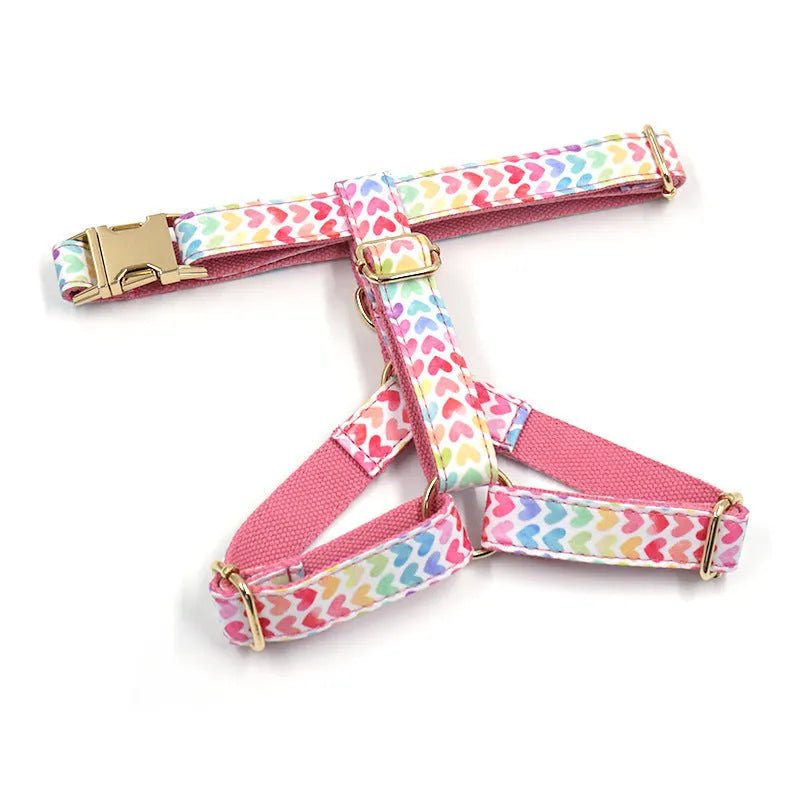 Pink colourful dog harness with gold buckle and heart-shaped stones on chest and back strap.