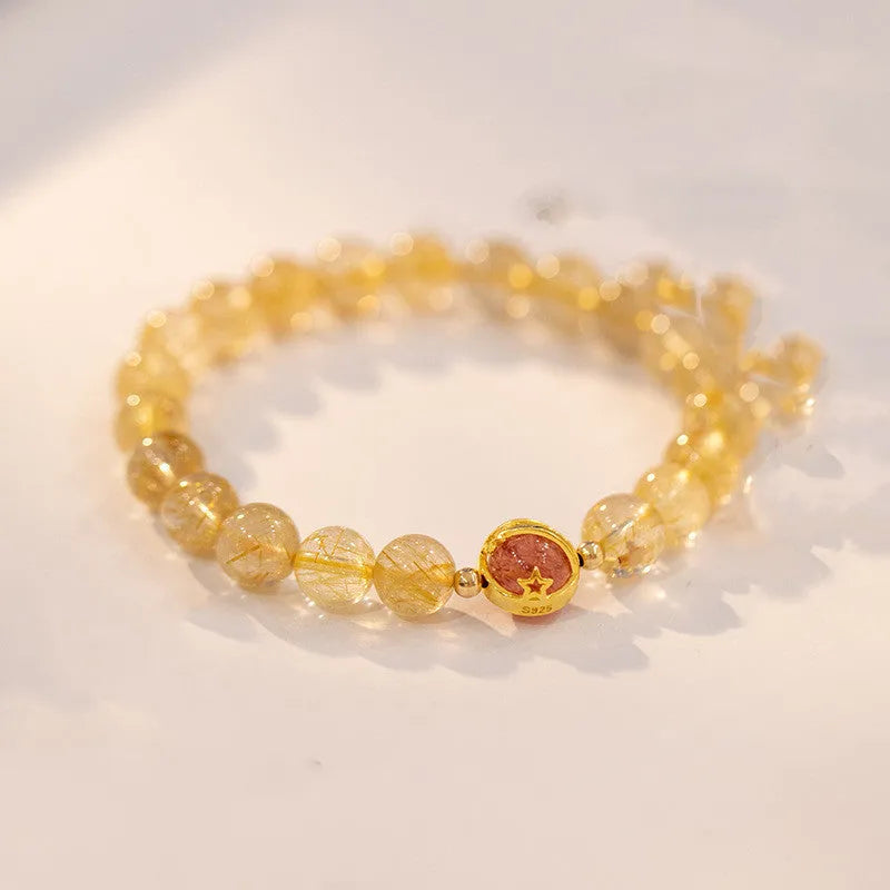 Gold rutilated quartz crystal bracelet with diamond-shaped links and natural citrine beads