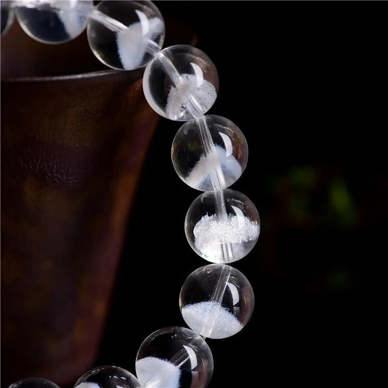Women's adjustable white crystal bracelet with a pyramid bead and ruyi charm, shown on a wrist.