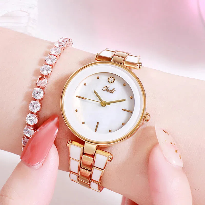 White dial ladies quartz watch with rose gold accents, steel strap, 30mm round alloy case on flat surface