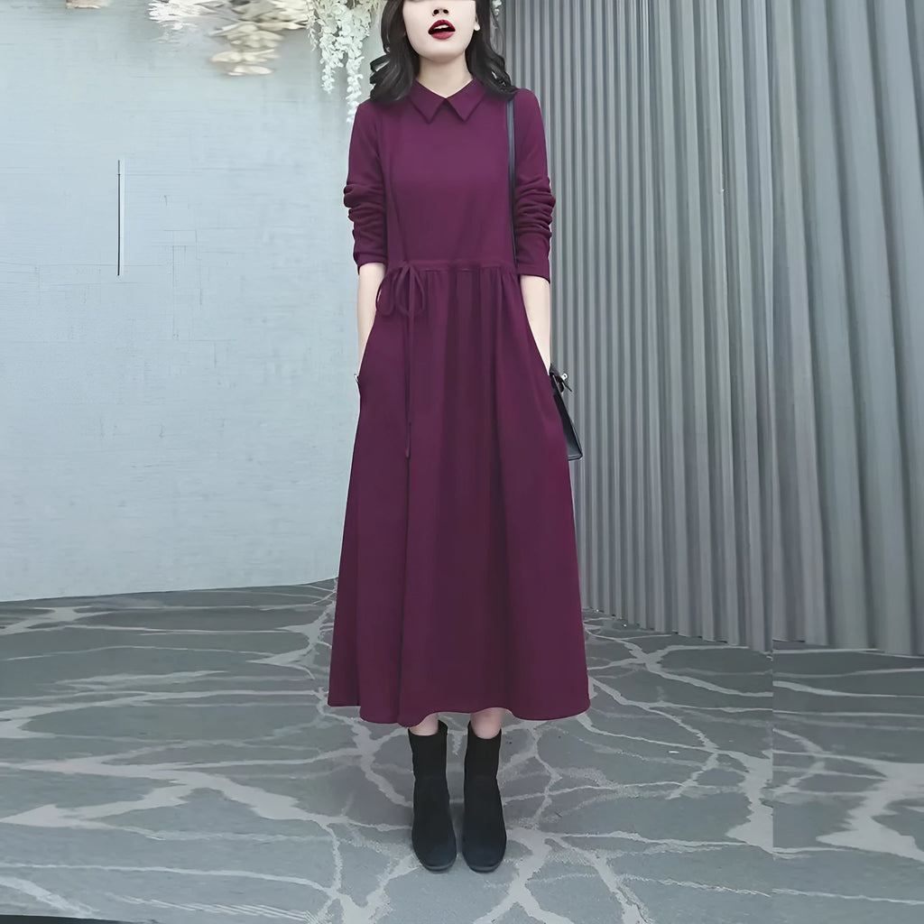 Purplish red women's plus size long sleeve dress with a long skirt on a hanger.