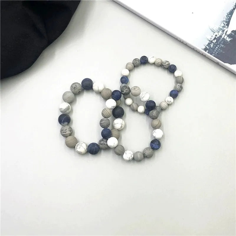 Handmade natural planet stone bracelet with starry design on a wrist, showing U-shaped profile.