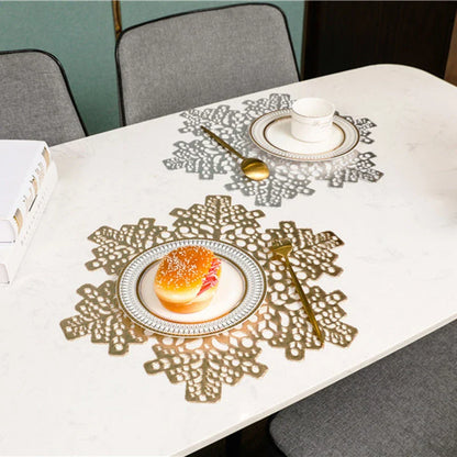 Stylish snowflake-patterned placemats in gold and silver, designed for heat resistance and spill protection on dining tables