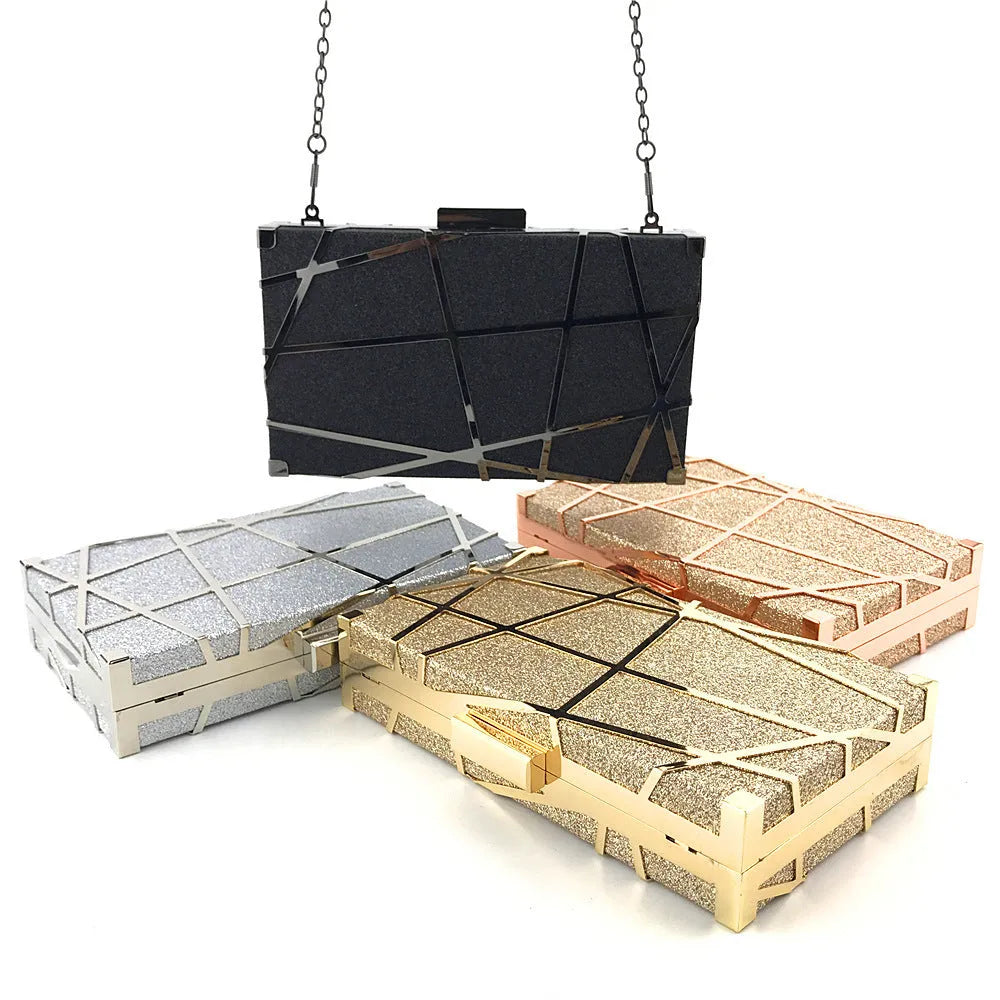 Gold glitter evening clutch bag with metal chain and lock closure on a table