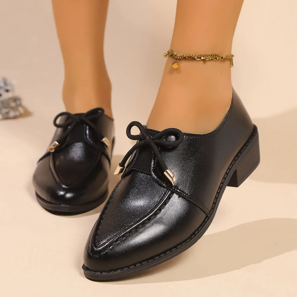 Women's pointed toe PU leather shoes with a bow detail on the upper.