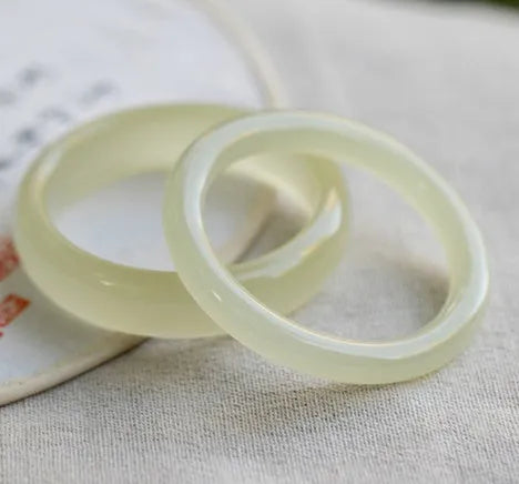Polished ice-like silk jade round bar bracelet showing its geometric shape and smooth surface