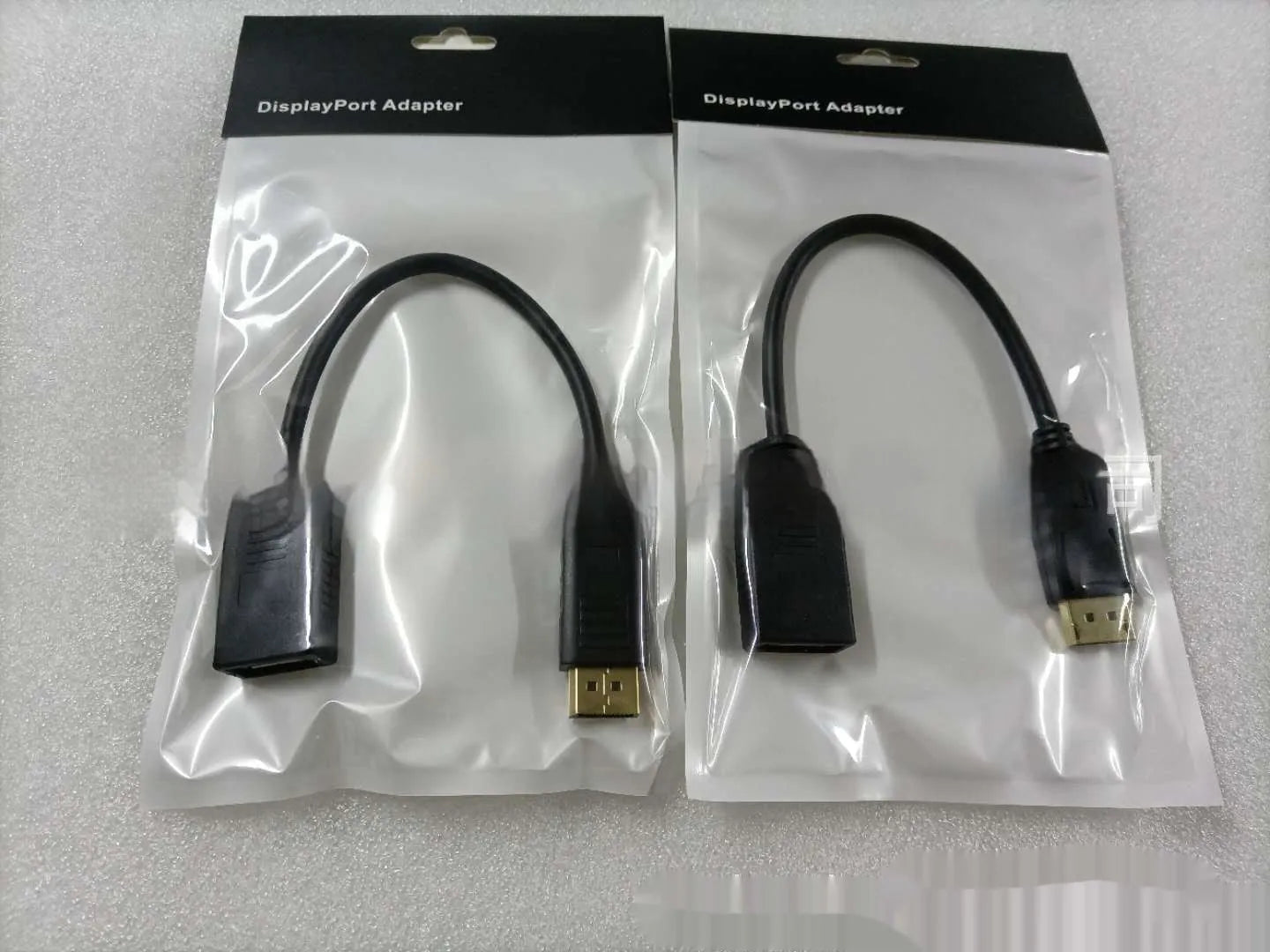 Black DisplayPort male to female extension cable with rotating busbar, approximately 10cm long