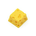 Yellow resin artisan keycap with a three-dimensional cheese design for mechanical keyboards.