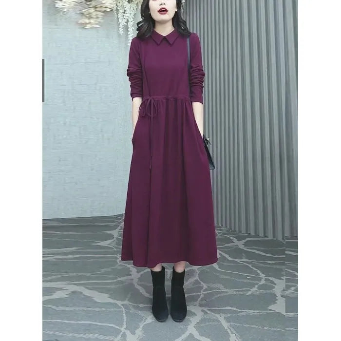 Purplish red women's plus size long sleeve dress with a long skirt on a hanger.
