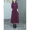Purplish red women's plus size long sleeve dress with a long skirt on a hanger.