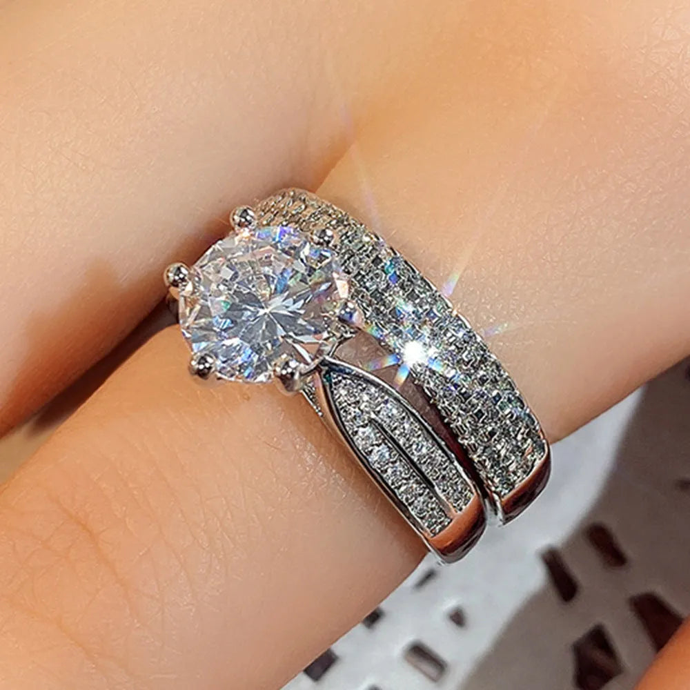Geometric white gold colour alloy wedding ring on a finger, showing its round design.