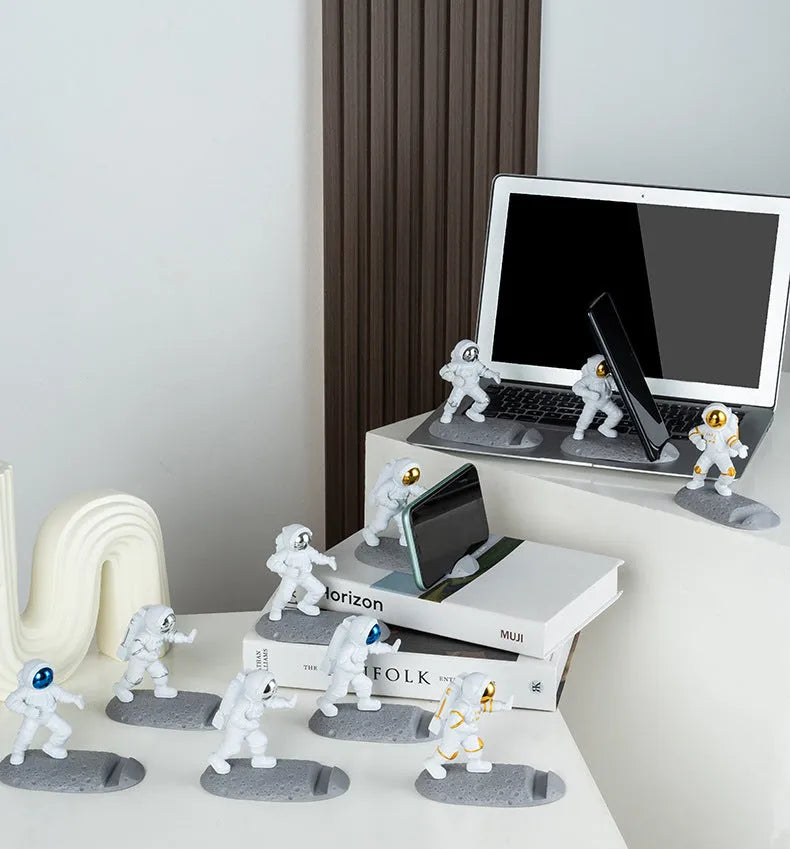 Plastic astronaut decoration mobile phone holder in blue colour on a desk