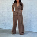 Brown men's slim fit polyester suit set comprising a long-sleeve top and matching trousers on a hanger.