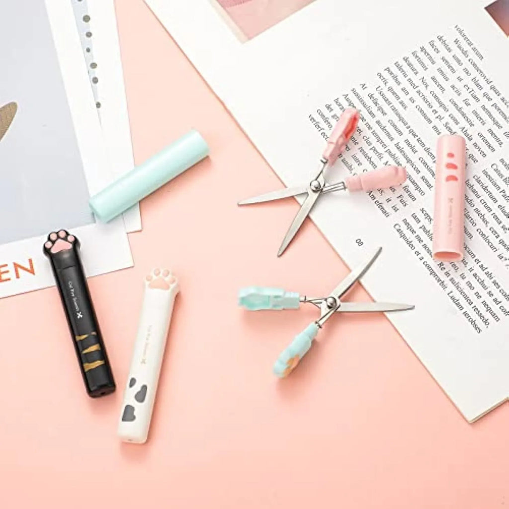 Set of four colourful mini folding scissors with cat paw handles on a white background.