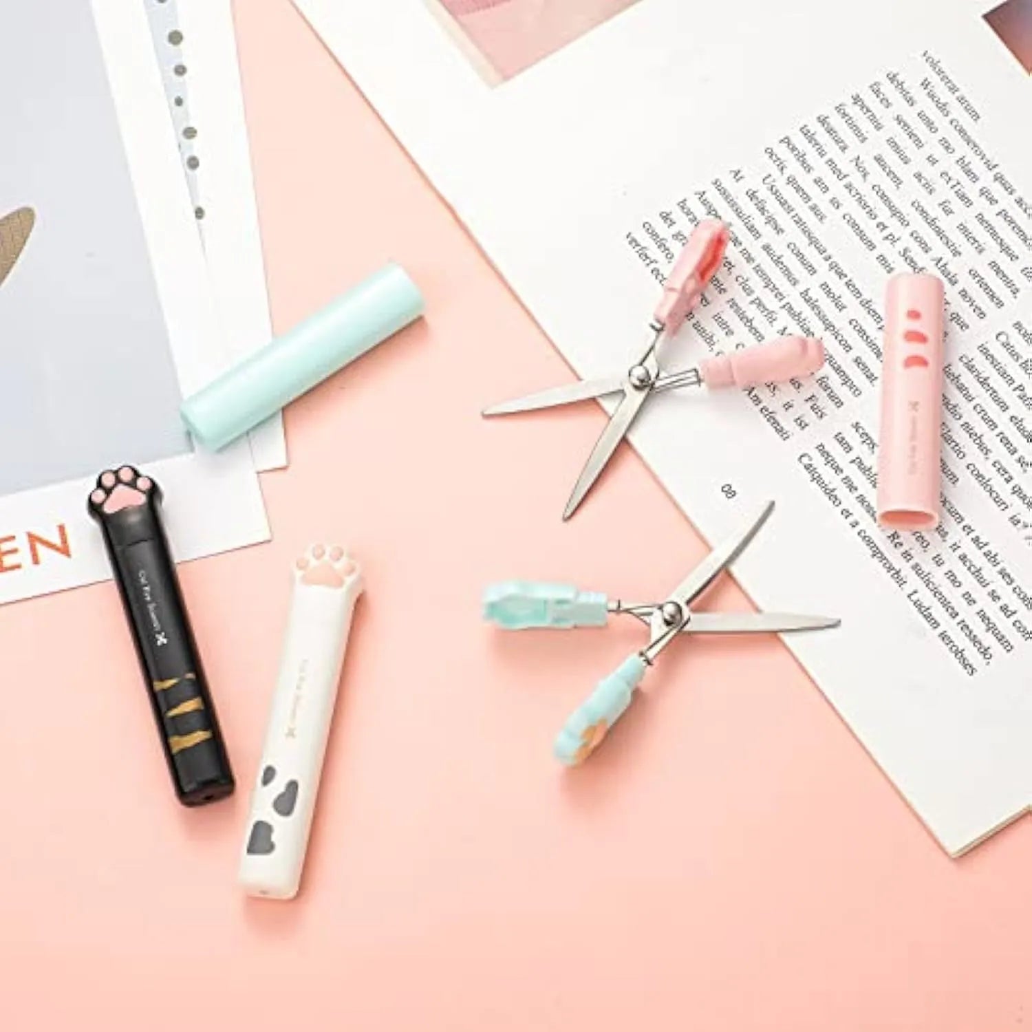 Set of four colourful mini folding scissors with cat paw handles on a white background.
