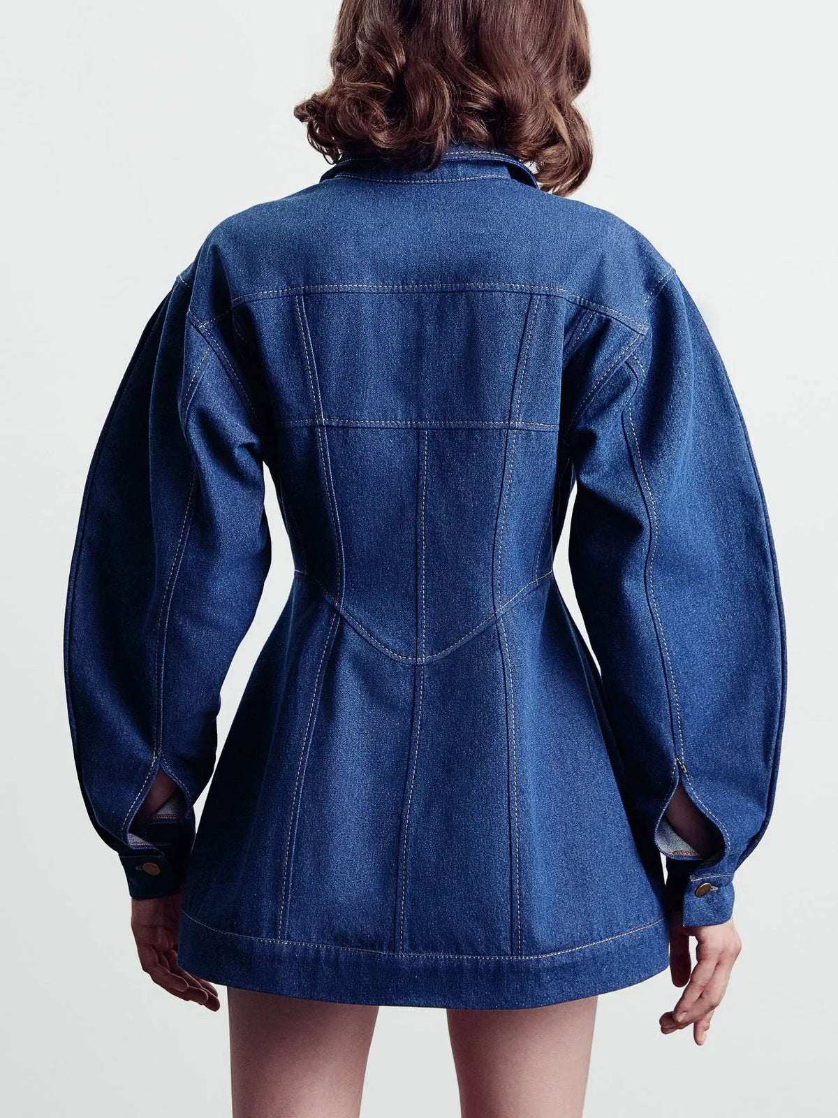Blue denim corset-style shirt dress with patchwork design and statement buttons on a model, mini length