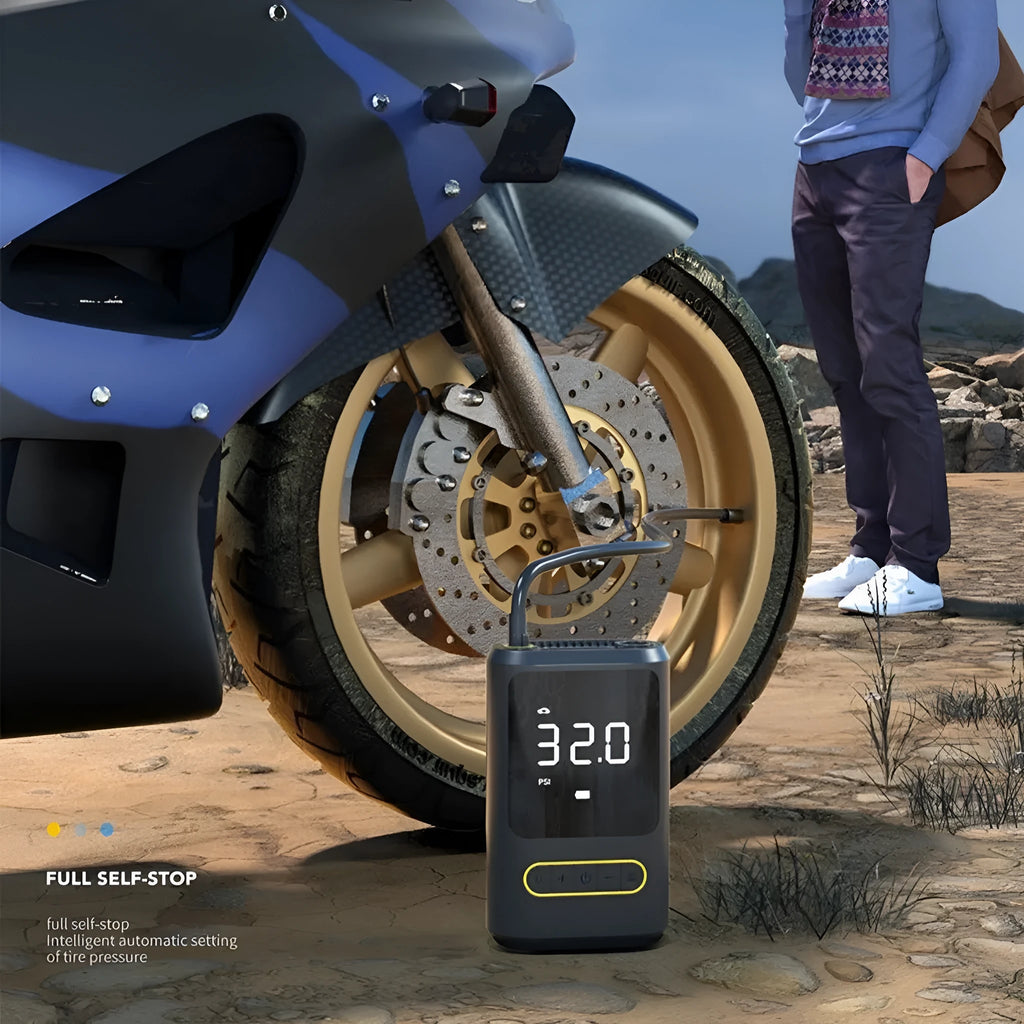 Black mini portable wireless car tyre inflator pump with LED light and air hose on dark background