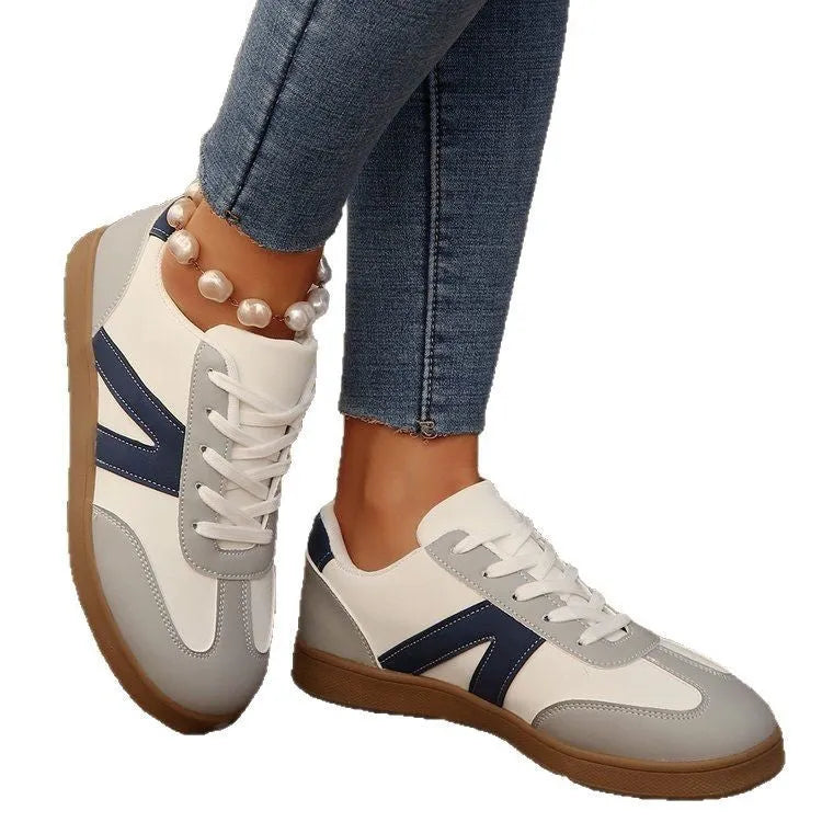 Blue women's low-top hiking shoes with rubber sole and lace-up design on an outdoor background.