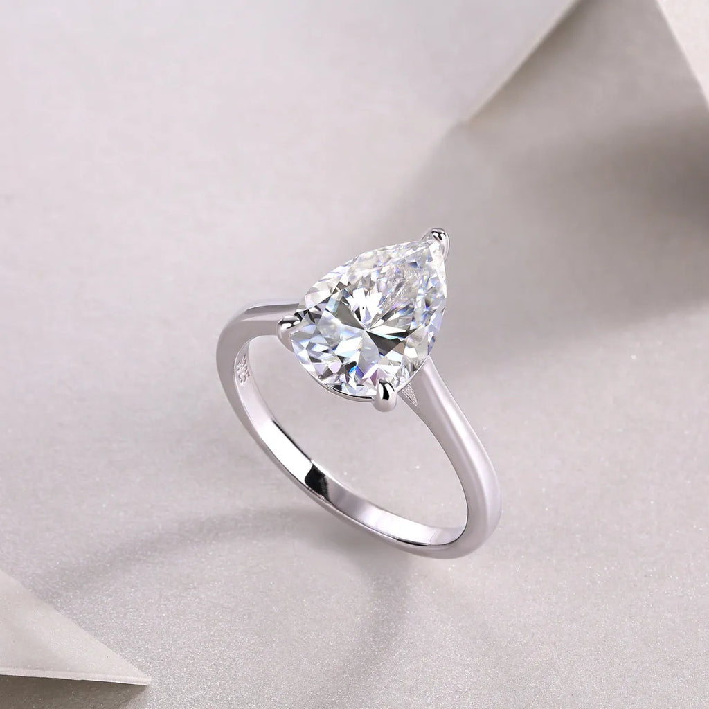 Heart-shaped pear-cut moissanite wedding ring set in S925 silver with platinum plating on white background