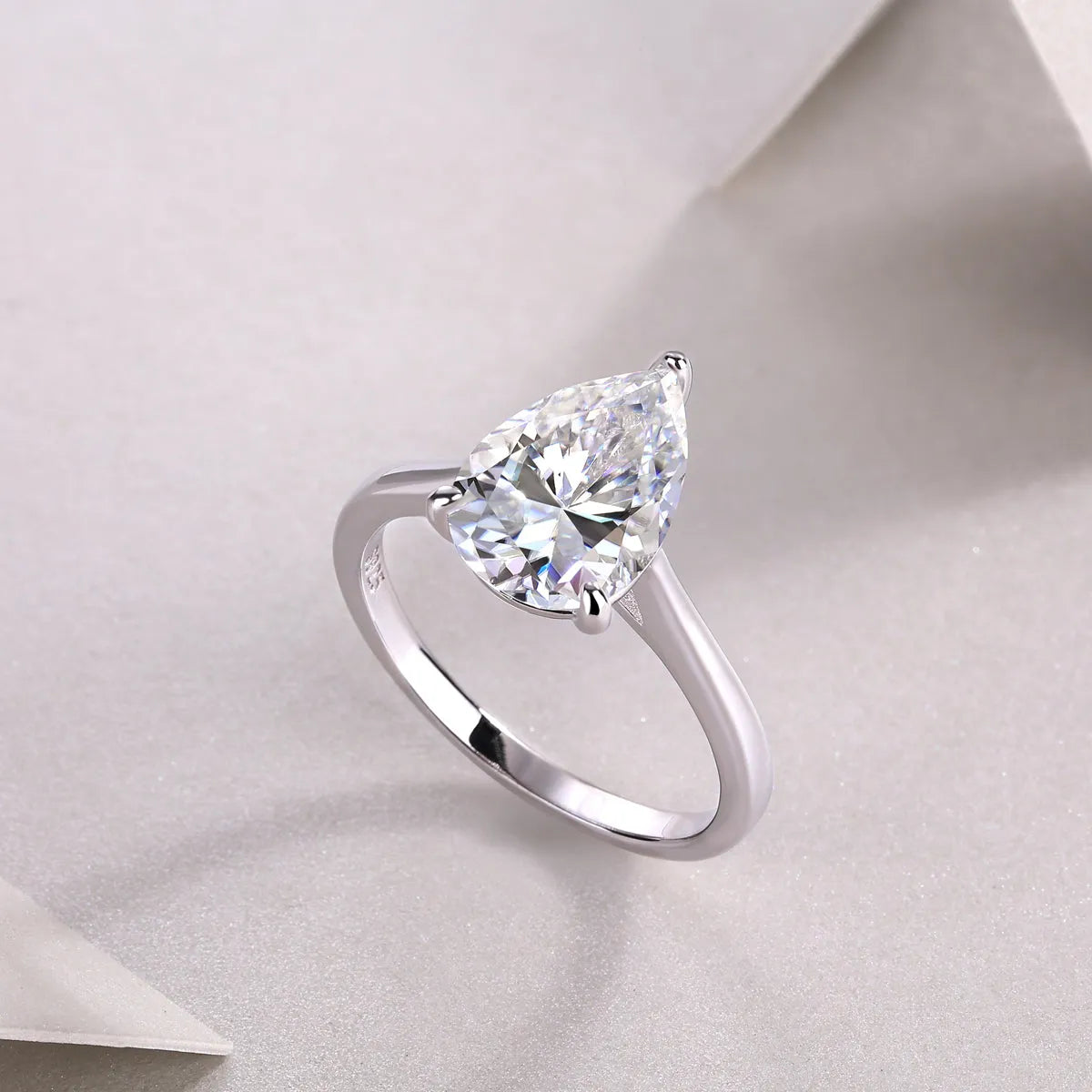 Heart-shaped pear-cut moissanite wedding ring set in S925 silver with platinum plating on white background