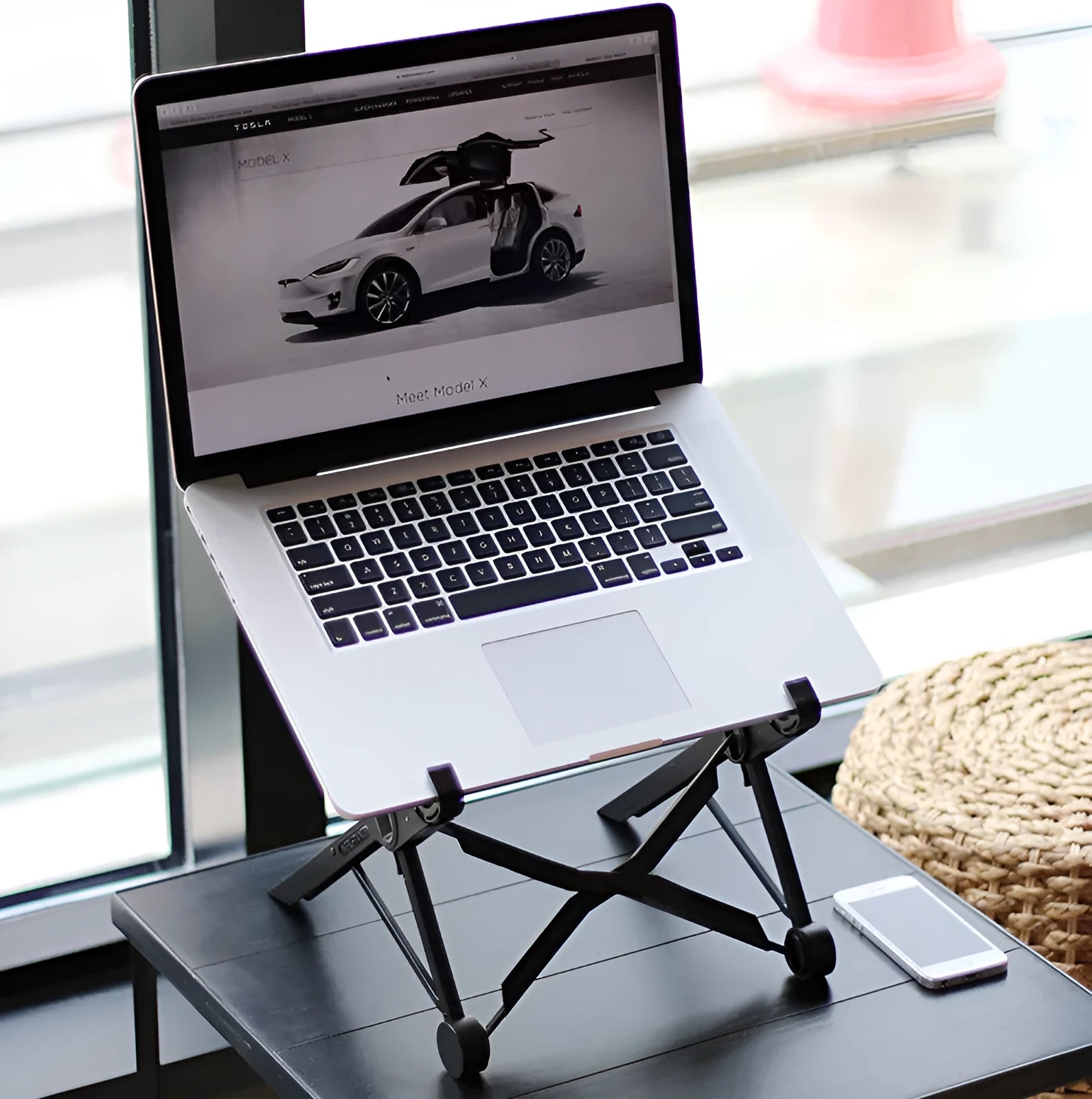 Black folding portable laptop stand made from reinforced nylon, shown in both open and compact folded positions.