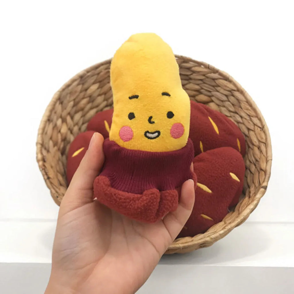 Red sweet potato-shaped dog toy with a peelable layer and hidden treat pocket for interactive play.