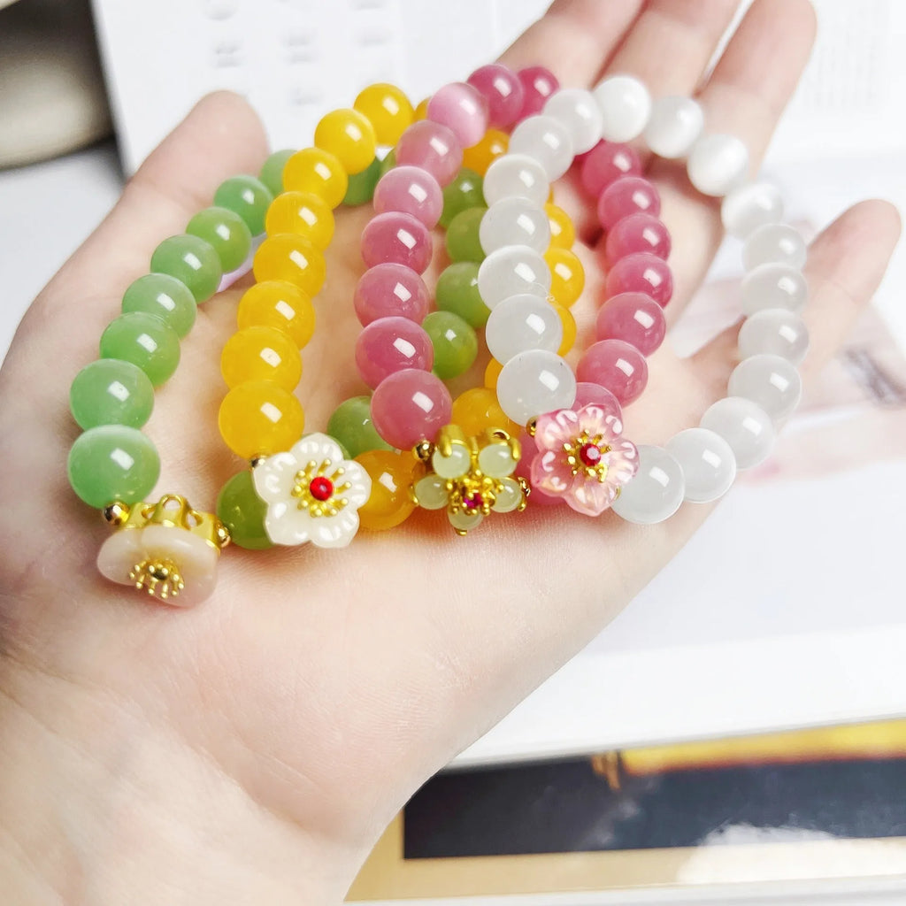Handmade glass beaded bracelet with floral design in yellow, pink, white, or green colour options.