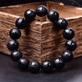 Natural frosted black agate Sanskrit mantra bracelet with Chinese style auspicious patterns on a wrist.